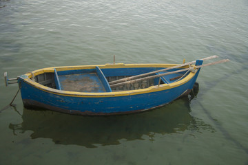 Blue and yellow fisherman boat in the harbor of Molfetta, South Italy.