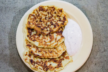 Zucchini pancakes with cream sauce from sour cream