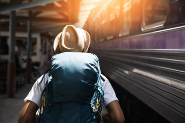 Young asian traveler with backpack in the railway, Backpack and hat at the train station with a...