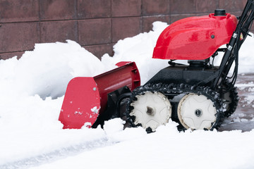 Man cleaning driveway after a snow storm, Snow removal equipment working on the street, Cleaning of...