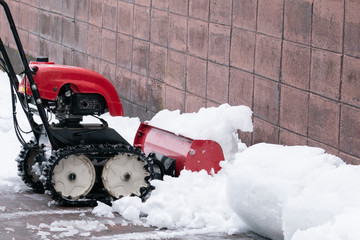 Man cleaning driveway after a snow storm, Snow removal equipment working on the street, Cleaning of...