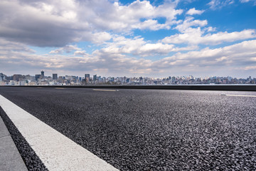 empty asphalt road with city skyline