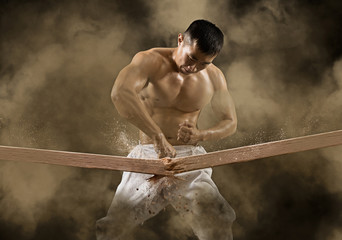 Karate-Mann bricht mit Hand Holzbrett