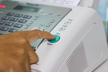 hand man are using a fax machine in the office. Business concept 