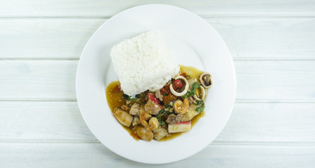 Fried Basil seafood in a white plate on wood floor table,fork and spoon,Top view, Thai food, Copy Space..