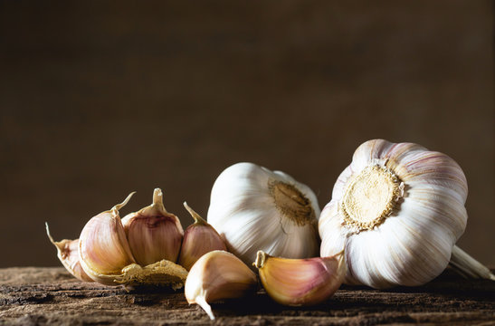 Closeup garlic on wooden texture on for cooking on dark background