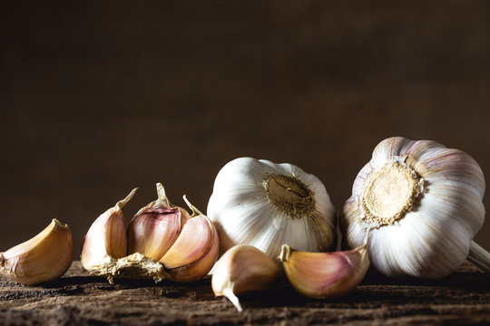 Closeup garlic on wooden texture on for cooking on dark background