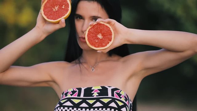 Fun woman plays with grapefruit