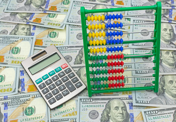 Image of abacus and calculator on money background