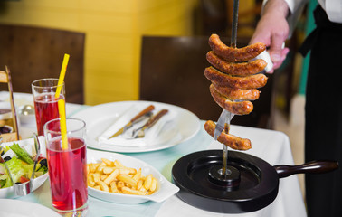 hand chef chef with a knife cleans meat from a skewer