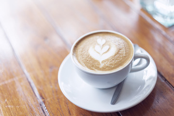 A cup of coffee latte on the wood table.