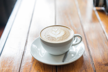 A cup of coffee latte on the wood table.