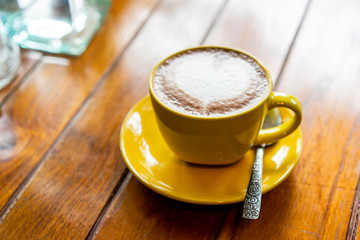 A cup of coffee latte on the wood table.