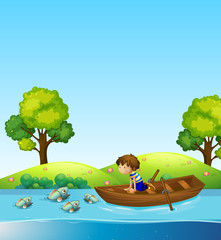 Fototapeta na wymiar A boy on the boat watching fish