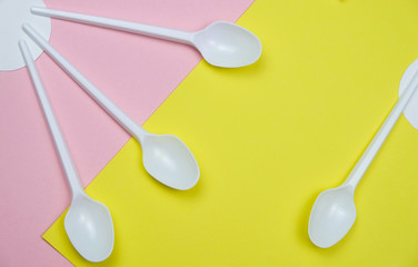 White Plastic Spoons On The Pastel Yellow And Pink Colors Background Abstract Geometry Minimal Art Flat Lay Copy Space