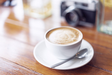 A cup of coffee latte on the wood table.