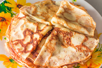 Appetizing folded in triangles pancakes on a plate