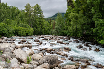 High flowing Little Susitna River along Hatcher Pass in Alaska on an overcast day
