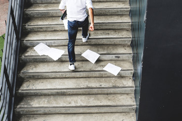 businessman hurrying time with papers document on ground
