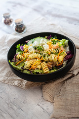 Salad with fusilli pasta accompanied tomatoes, mozzarella, smoked ham and italian cheese