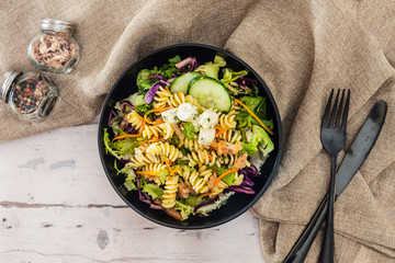 Salad with fusilli pasta accompanied tomatoes, mozzarella, smoked ham and italian cheese