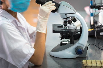 Asian technician tests the quality of product in laboratory closeup