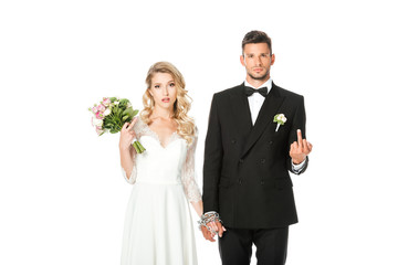 young bride and groom holding hands and showing middle fingers at camera isolated on white