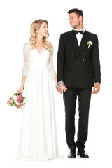beautiful young bride and groom holding hands and looking at each other isolated on white