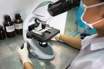Asian technician tests the quality of product in laboratory closeup
