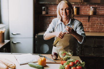 Senior Woman Cooking Salad in Kitchen at Home