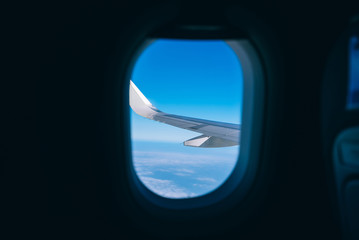 airplane wing with blue sky and cloud