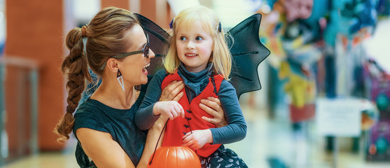 smiling elegant mother and daughter on Halloween at mall © Alliance
