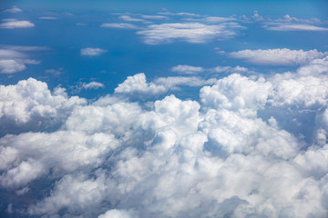 Naklejka na ściany i meble Blue sky, white clouds cover the earth background. Aerial photo from airplane's window.