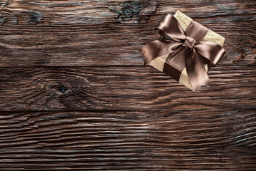Brown wrapped gift box on vintage wooden board