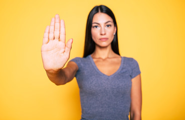 Stop sign, palm, hand on camera, symbol - don't move. Close up photo of young serious woman shows...
