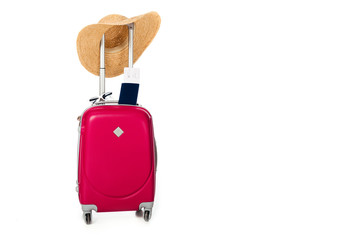 close up view of pink suitcase, straw hat, passport and ticket isolated on white