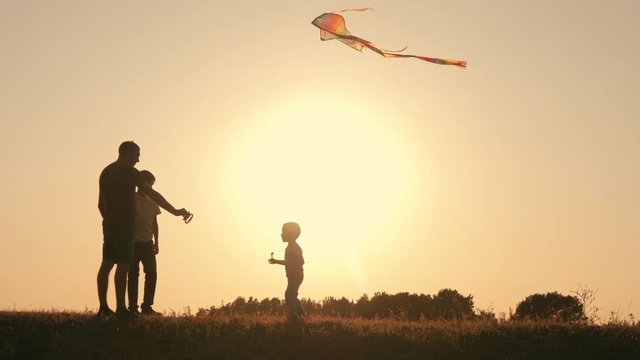 A happy family. Family in the summer at sunset launch a kite into the sky.