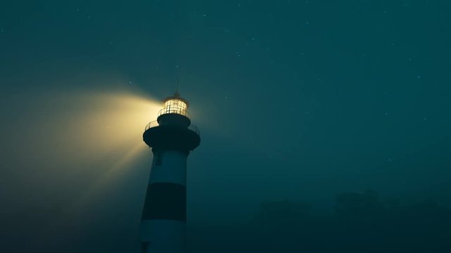 Lighthouse light spinning around. Tall tower standing on the coastline.
