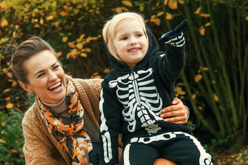 mother and daughter on Halloween at park pointing at something