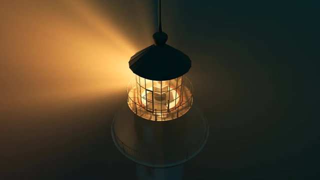 Lighthouse light spinning around. Tall tower standing on the coastline.
