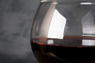 Red wine in wineglass on a gray background