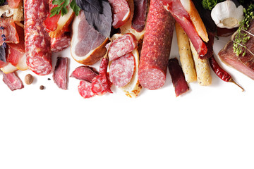 assortment of meat products including sausage ham bacon spices garlic on a white background...