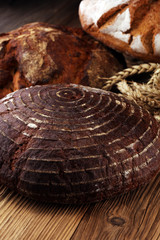 Different kinds of bread and bread rolls on board from above. Kitchen or bakery