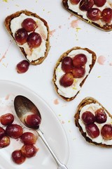 Ricotta and roasted grapes toasts isolated on white