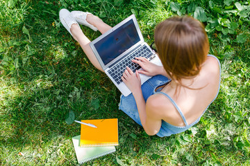 Business woman with laptop in the park sitting on a folding chair