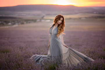 Fototapeta na wymiar Woman in amazing dress walk on the lavender field.