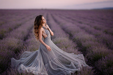 Woman in amazing dress walk on the lavender field.