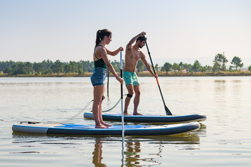 Man and woman stand up paddleboarding