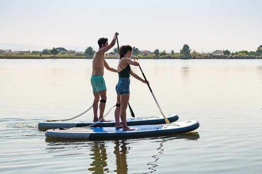 Man and woman stand up paddleboarding