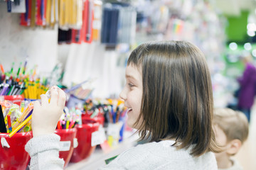 Obraz na płótnie Canvas schoolgirl choosing office supplies